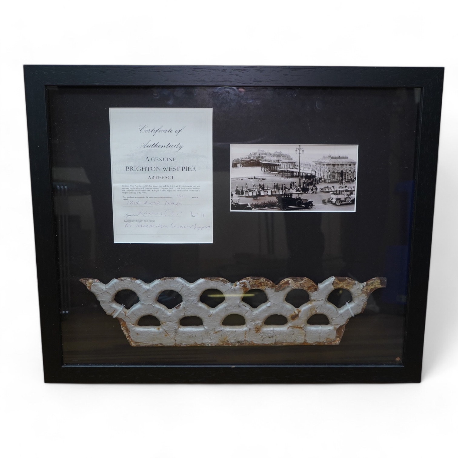 A framed part of the original frieze from the West Pier in Brighton, a photo and certificate, plus a book about the West Pier, 50cm wide, 40cm high. Condition - good